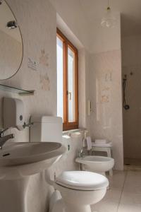 Baño blanco con aseo y lavamanos en Hotel Villa Rita en Marciana
