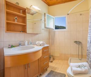 a bathroom with a sink and a toilet and a window at oli terra in Lefkada