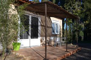 a patio with a table and chairs under a pavilion at Gite L'Acacia in Lagorce