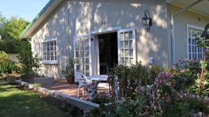una casa con una mesa y sillas en un patio en Daisy Place, en Franschhoek