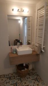 y baño con lavabo blanco y espejo. en Kolbergarden, en Olsztyn
