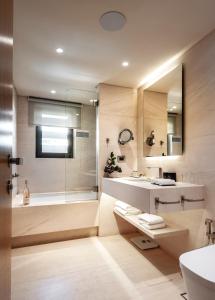 a bathroom with a tub and a sink and a shower at Somewhere Vouliagmeni in Athens