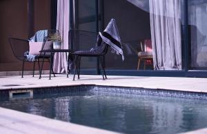 2 sillas sentadas junto a una piscina en The Desert Grace, en Solitaire