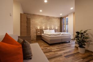 ein Schlafzimmer mit einem Bett und einem Sofa in einem Zimmer in der Unterkunft Hotelmyhome in Hornberg