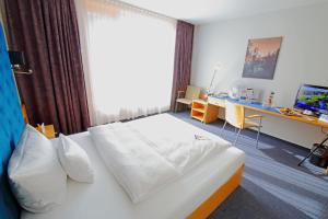 Postel nebo postele na pokoji v ubytování rugs Hotel am Schlosspark Lichtenwalde