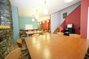 comedor con mesas y sillas de madera en Albergue O Durmiñento, en Sarria