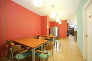 a dining room with orange walls and wooden tables and chairs at Albergue O Durmiñento in Sarria