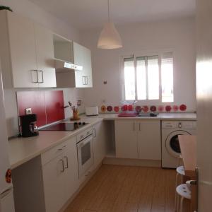 a kitchen with white cabinets and a washer and dryer at Pepe y Nina in Las Lagunas