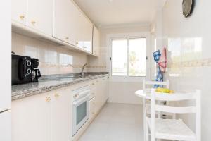 cocina blanca con fregadero y microondas en Apartment Muchavista 3 bed 2 bath, en El Campello