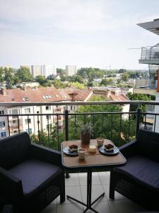 a balcony with a table with plates of food on it at Apartament Sunrise Spacerowa by Renters in Kołobrzeg