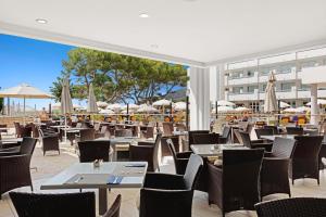 
a restaurant with tables, chairs, tables and chairs at Alua Gran Camp de Mar in Camp de Mar
