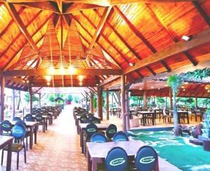a row of tables and chairs in a pavilion at De Baron Resort in Kuah