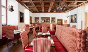 a restaurant with red booths and tables and chairs at Living Hotel De Medici in Düsseldorf