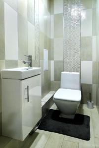 a bathroom with a white toilet and a sink at PaulMarie Apartments on Chigrinova in Mogilev