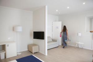 una mujer caminando por una sala de estar con sofá en Ibersol Antemare - Adults Only, en Sitges