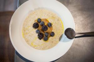 a bowl of oatmeal with blueberries and a spoon at The Grosvenor Arms in Shaftesbury