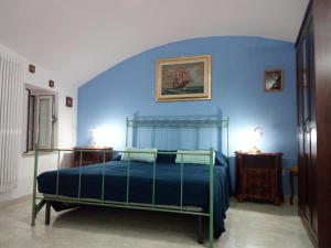 Schlafzimmer mit einem Bett mit blauer Wand in der Unterkunft Porto in Vista in Monopoli