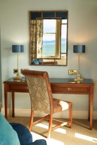 a chair and a desk in a room at Golf View Hotel & Spa in Nairn