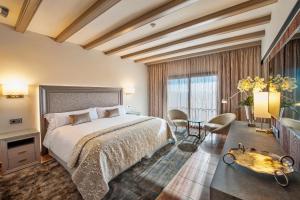 a bedroom with a large bed and a table and chairs at Hotel La Caminera Club de Campo in Torrenueva