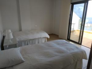 サンタ・クルス・デ・ラ・パルマにあるAtico luminosoのベッドルーム1室(ベッド2台付)が備わります。バルコニーの景色を望めます。
