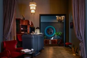 Hotel Collect - Adults Only في بودابست: غرفة معيشة مع ثلاجة زرقاء وكرسي احمر