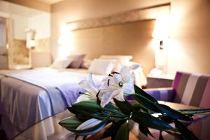 una habitación de hotel con una mesa con una flor. en Hotel & Winery Señorío de Nevada, en Villamena 