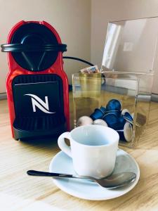 a cup of coffee on a plate next to a coffee maker at Belsiana Luxury Apartment in Rome +9 photos