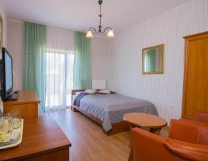 ジビジノにある11 Dębów Willa nadmorskaのベッドルーム(ベッド1台、テーブル、テレビ付)