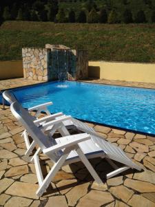 uma cadeira branca ao lado de uma piscina em Pousada Recanto das Orquideas em Santo Antônio do Pinhal