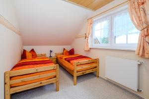 2 Einzelbetten in einem Zimmer mit Fenster in der Unterkunft Ferienhaus "Jägers Ruh" in Wernigerode
