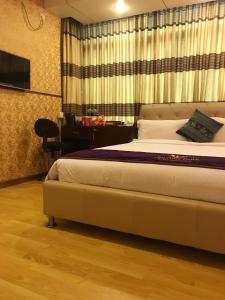 a hotel room with a bed, chair, and nightstand at Century Park Residence in Dhaka
