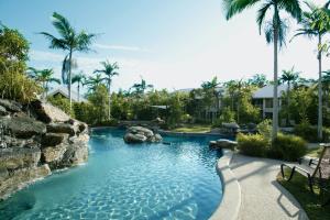 una piscina in un resort con palme di Paradise Links Resort Port Douglas a Port Douglas