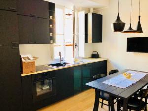 a kitchen with a table with chairs and a counter top at Belsiana Luxury Apartment in Rome