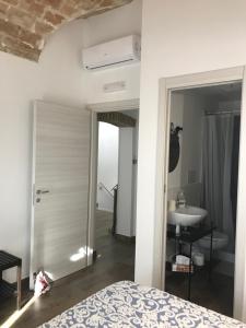 um quarto com uma cama e uma casa de banho com um lavatório em Il Torrione em Tarquinia