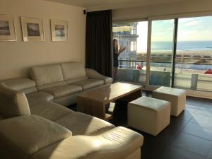 a living room with a couch and a table at Panoramic view on beach, ships, sea - place to be in Ostend
