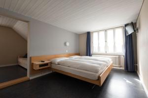 ein Schlafzimmer mit einem Bett und einem großen Fenster in der Unterkunft Gasthof Pizzeria Weingarten in Affoltern