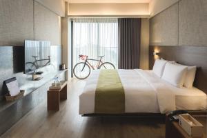 a hotel room with a bed and a bike on the wall at Kadda Hotel in Hualien City