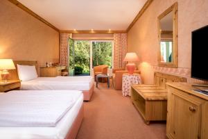 a hotel room with two beds and a television at GolfResort Semlin in Semlin