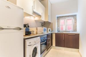 a kitchen with a washing machine and a washer at LX 77 in Lisbon