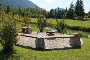 a swing set in a field with a lake at Ferienhof Zum Sagschneider in Lenggries