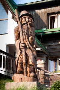 a wooden statue of a man holding a stick at Penzion Pohlednička in Benecko