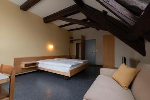 ein Schlafzimmer mit einem Bett und einer Couch in der Unterkunft Gasthof Pizzeria Weingarten in Affoltern