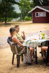 un grupo de personas sentadas en una mesa de picnic en Haga Park Camping & Stugor, en Mörbylånga