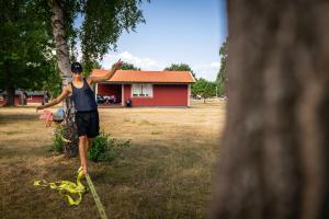 摩爾比蘭加的住宿－Haga Park Camping & Stugor，一个人站在一棵树旁边,绳子