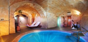 a swimming pool in a building with a brick wall at Casal Santa Eulalia in Can Picafort
