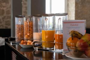 einen Tisch mit Gläsern aus Orangensaft und Obst in der Unterkunft Gasthof Pizzeria Weingarten in Affoltern