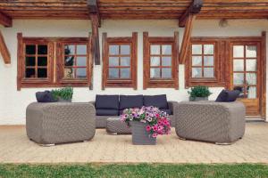 a patio with couches and flowers in front of a building at La Ferme du Golf in Megève