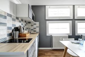 eine Küche mit einer Arbeitsplatte und 2 Fenstern in der Unterkunft My Toul'House SPA in Toulouse