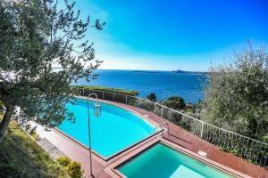 a swimming pool with the ocean in the background at La Villa Fasano in Gardone Riviera