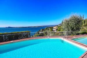 a swimming pool with a view of the water at La Villa Fasano in Gardone Riviera